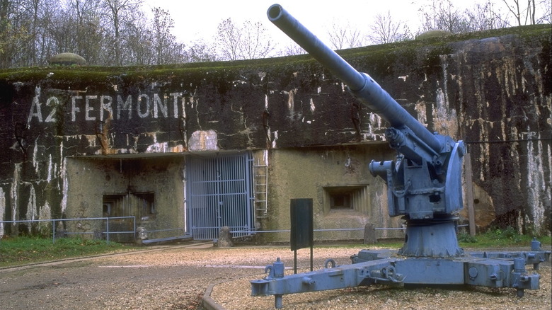 Old concrete bunker with artillery gun to the right.