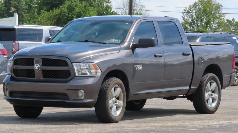 Grey 2017 Dodge Ram pickup in school parking lot with other vehicles and trees in background