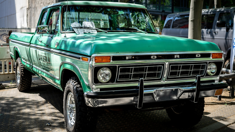 a green 1977 Ford F-250 pickup truck parked outdoors