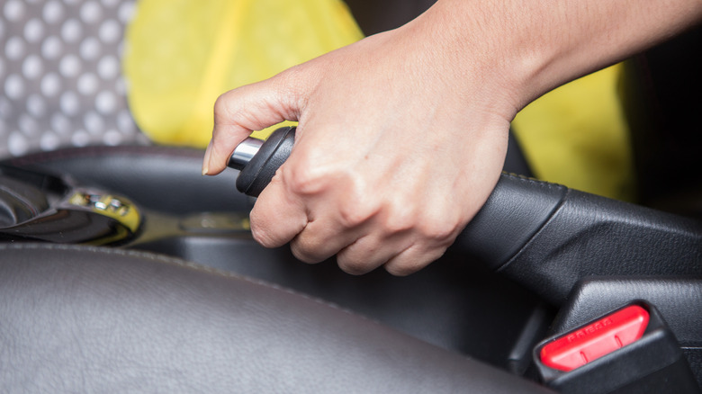 person holding emergency car brake