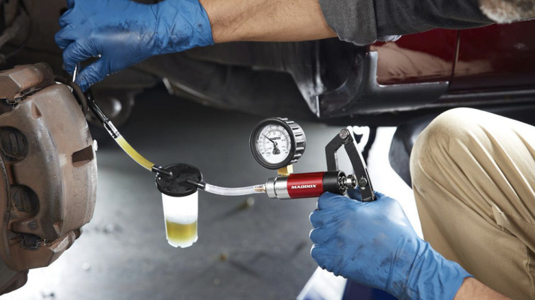 A brake bleeder pulling out blake fluid