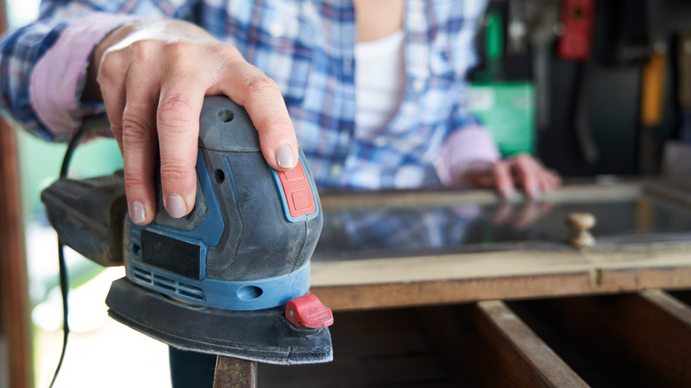 Person holding palm sander