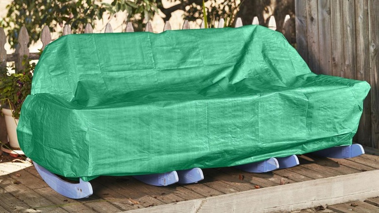 Green tarp covering outdoor furniture