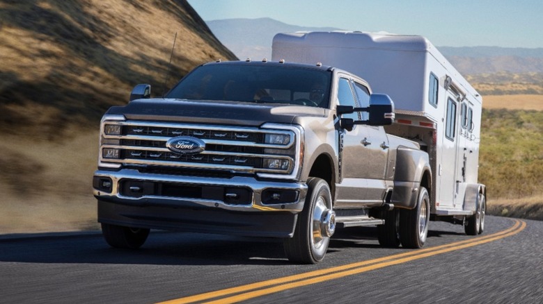 A Ford F-350 towing a large trailer uphill