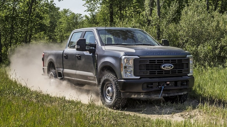 2025 Ford Super Duty pickup driving on dirt road