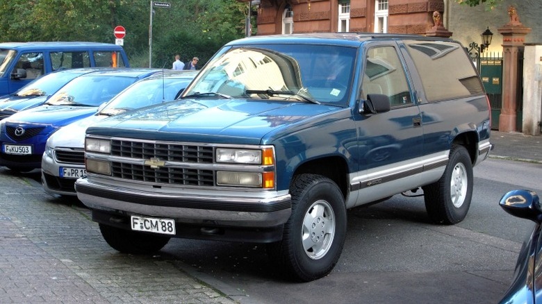 A 1992-1994 Chevrolet Full-Size Blazer parked by the roadside with a brown building in the background