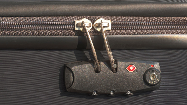 The zippers of a piece of luggage are locked with a TSA approved Travel Sentry lock