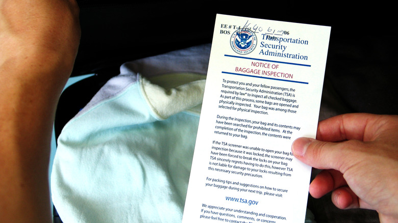 A person finds a TSA notice of baggage inspection in their bag