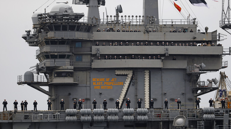 A U.S. Navy crew standing on the deck of an aircraft carrier