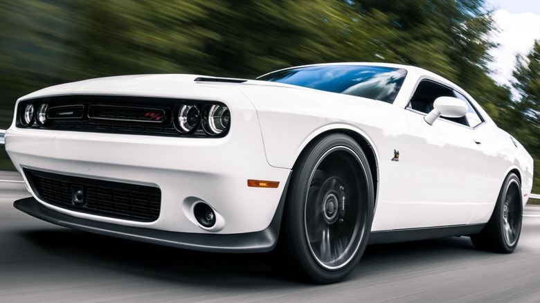 White 2022 Dodge Charger R/T driving on a tree-lined street