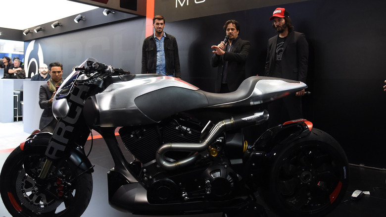 Keanu Reeves and others standing behind a new Arch motorcycle