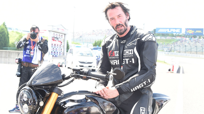 Keanu Reeves sitting on an Arch motorcycle, wearing Arch gear