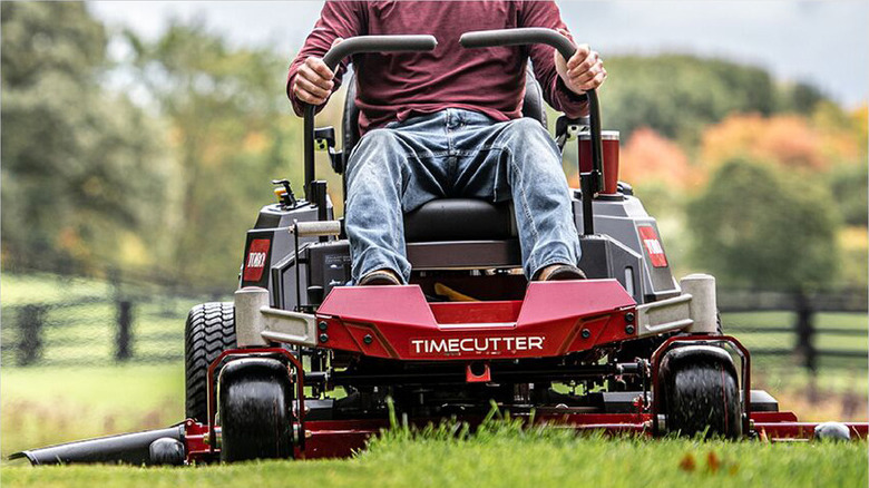 Man in red shirt riding Toro Timecutter zero-turn mower