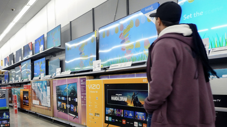 Person walking in front of a Vizio TV