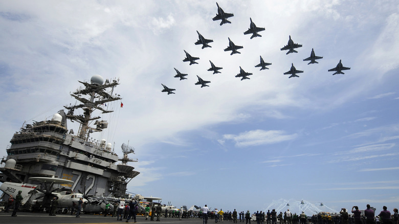 fighter jets fly over the USS Abraham Lincoln