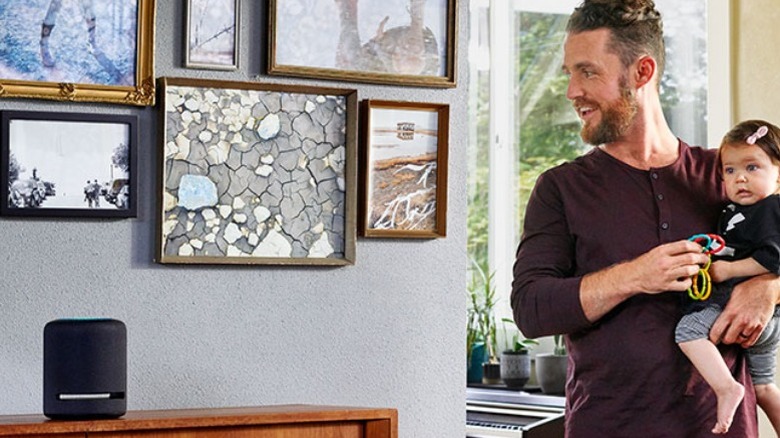 Man with baby looking at Amazon Studio on bookshelf