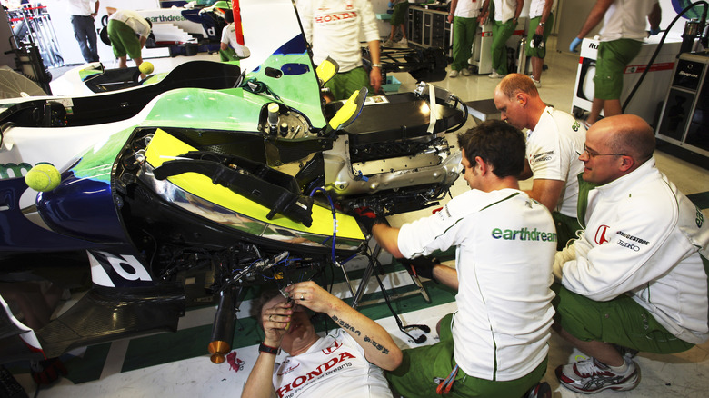 Honda Formula One mechanics working on Rubens Barrichllo's RA108 racing car and engine in the team's pit garage at the 2008 Spanish Grand Prix