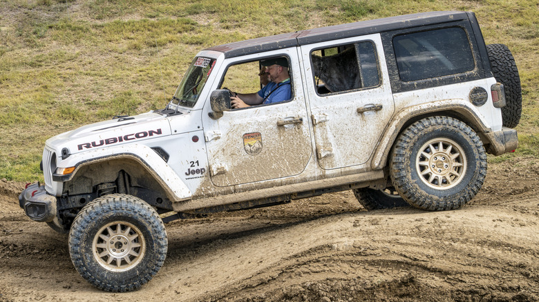 White Jeep Wrangler Rubicon off-roading over dirt dune