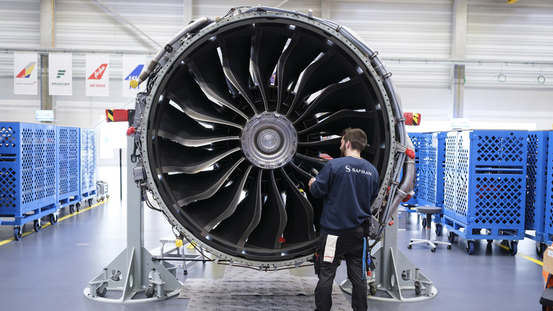 CFM employee inspecting a LEAP-1 engine while wearing a blue Safran shirt