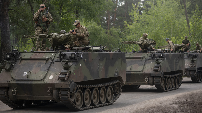 A convoy of armored personnel carriers.