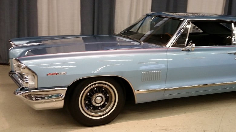 1965 Pontiac Catalina 2+2 hardtop coupe parked indoors with the front-left 8-lug wheel showing