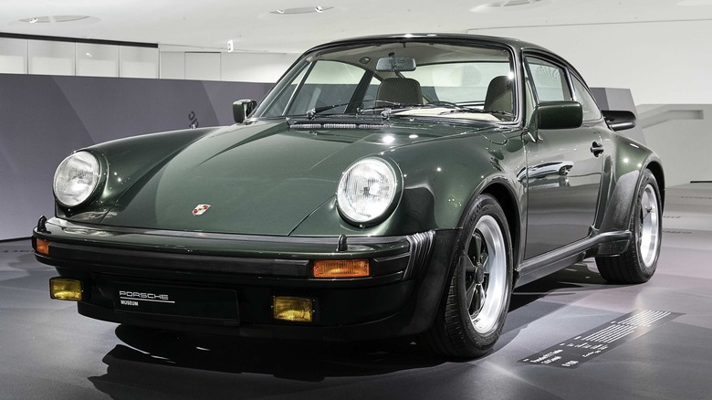 Forest green Porsche 911 Turbo in a light-colored museum display.