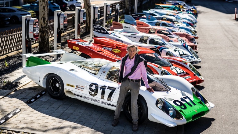 Hans Mezger standing in front of a row of Porsche 917s