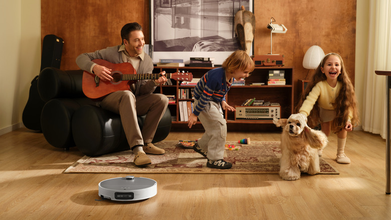 Family enjoying time together in a room as a Saros 10 cleans around them