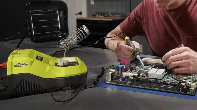 Person soldering a motherboard together