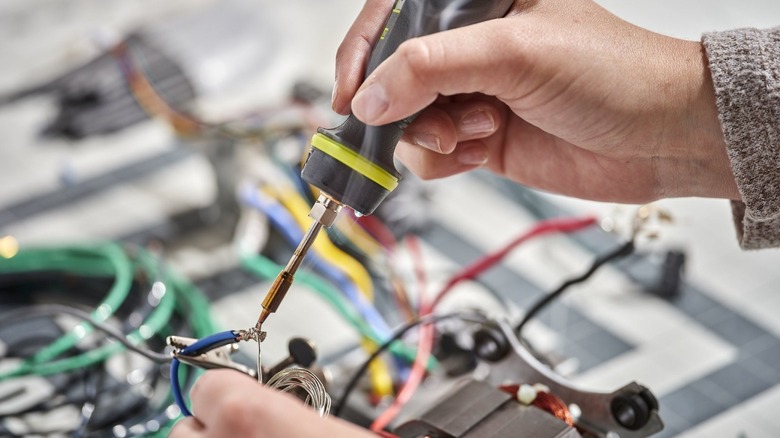 Person soldering wires together