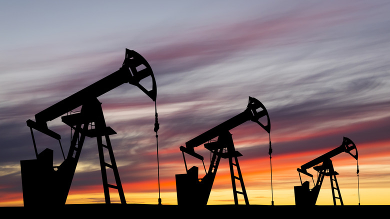 Three fracking pumps in use before a sunset.