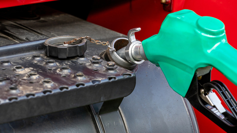 A machine being filled with diesel fuel via nozzle.