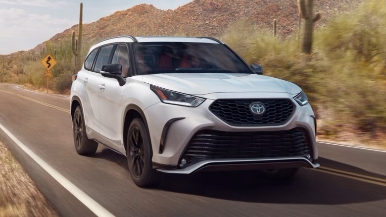 Wind Chill Pearl Toyota Highlander XSE driving on a road with mountains in the background