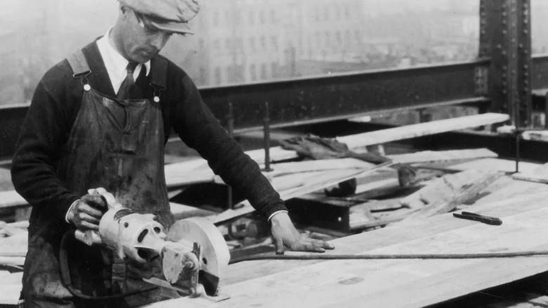 black and white image of man using old Skilsaw