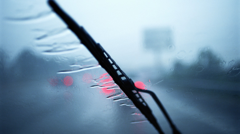 A windshield wiper clearing the water from the glass during a rain.