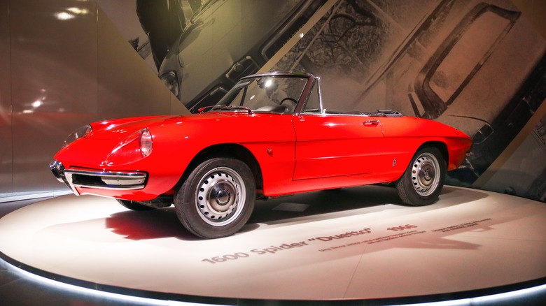 A red Alfa Romeo Duetto Spider 1600 on display at the Alfa Romeo Historical Museum.