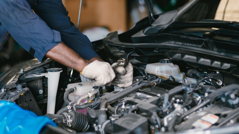 A mechanic working on a car's engine.