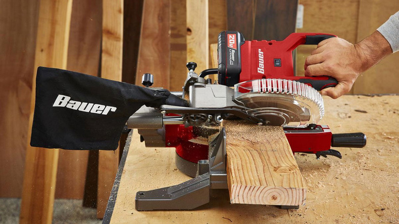 Bauer table saw with man cutting plank of wood