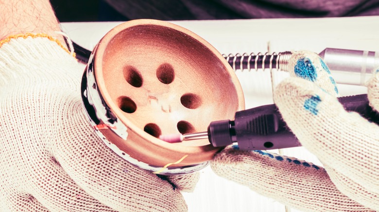 Person using Dremel on ceramic