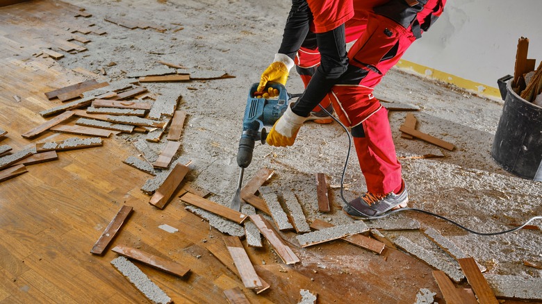 Worker drilling floorboards