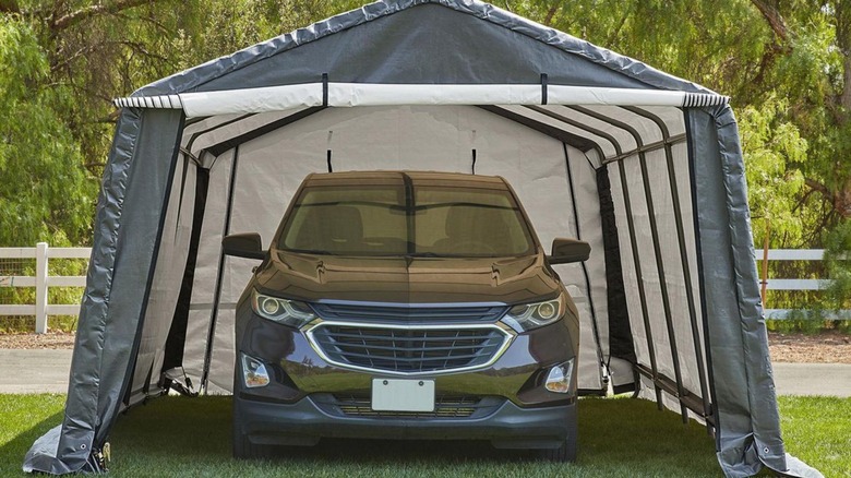 SUV inside a gray portable carport