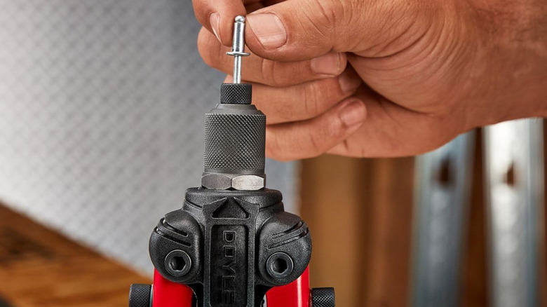 Person putting a rivet inside rivet gun