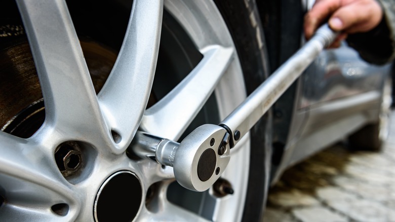 Person using torque wrench on car wheel