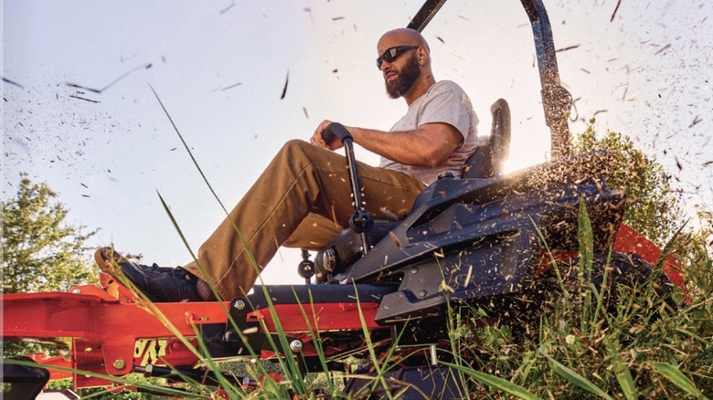 Man riding lawn mower with Kawasaki engine