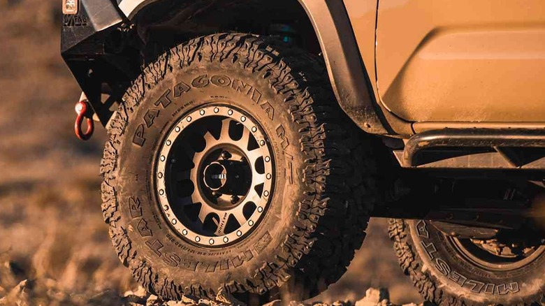 Sand and mud-drenched Milestar Patagonia tires photographed on a rugged trail