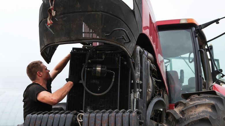 Person working on tractor engine