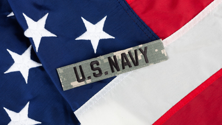 A U.S. Navy badge over the American flag