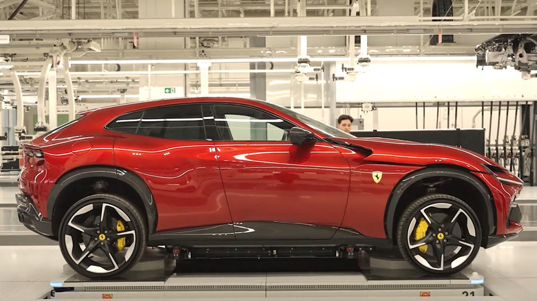 A person works on a red Ferrari in the company's Maranello, Italy factory.