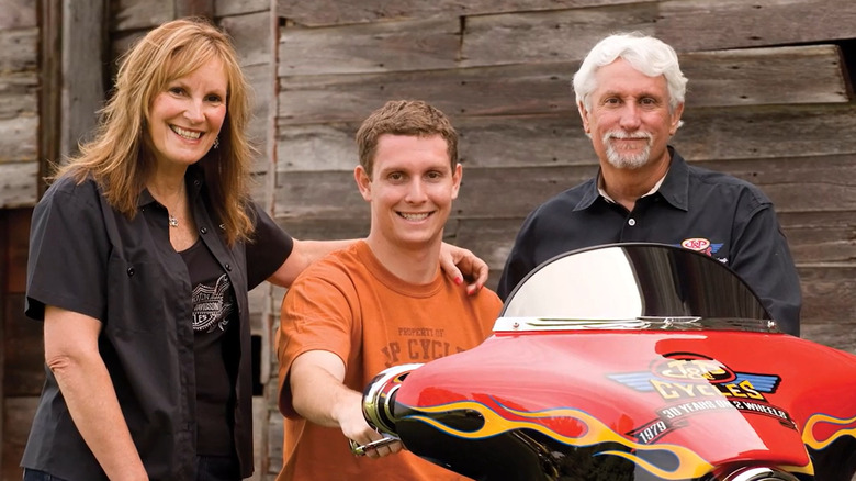 Jill, Zach, and John Parham pose for a photograph with Zach sitting on bike