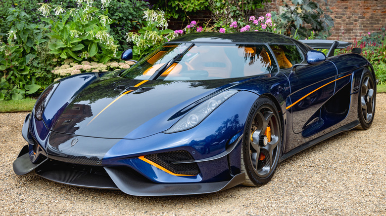 Koenigsegg car in front of flower garden